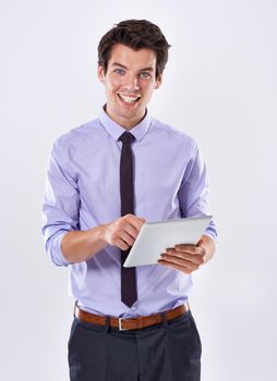 His companion in connectivity. Studio shot of a handsome young businessman against a white background using a digital tablet.