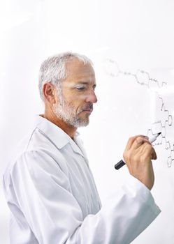 Mad about molecules. a mature male scientist drawing chemical bonds on a glass surface.