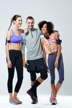 Friends forever in fitness. three young adults wearing sports clothing in a studio.