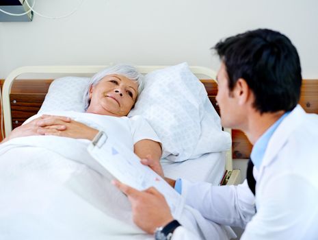 Finding comfort in his voice. a doctor discussing test results with his senior patient who is in a hospital bed.