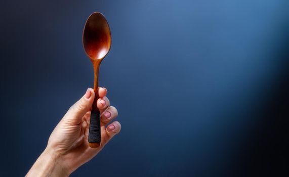 Hand holding wooden spoon