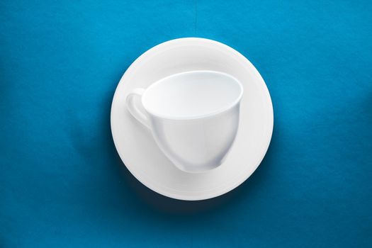 White tableware crockery set, empty cup on blue flatlay background