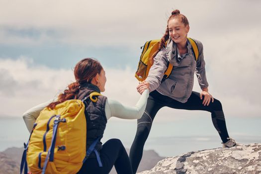 Help hands, friends or women hiking up a mountain, hill or in nature with a smile. Travel, adventure and trekking females on an outdoor, countryside or rock climbing recreation exercise activity.