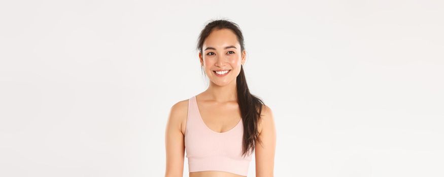 Sport, wellbeing and active lifestyle concept. Close-up of smiling happy asian girl workout in gym, looking healthy and pleased after productive fitness training, gaze upper left corner