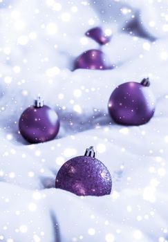 Violet Christmas baubles on fluffy fur with snow glitter, luxury winter holiday design background