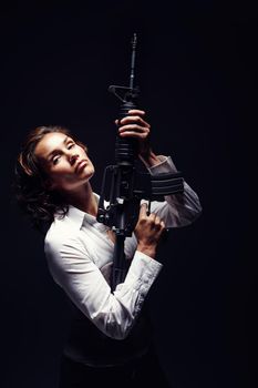 Controlled and confident. a mature woman holding a rifle and looking serious.