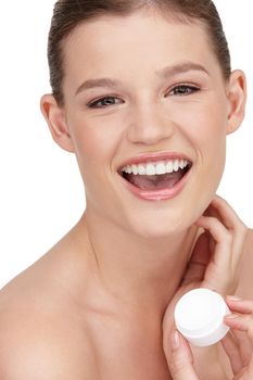 Celebrating clear skin. Close-up shot of a pretty teenage girl holding a tub of moisturizer.
