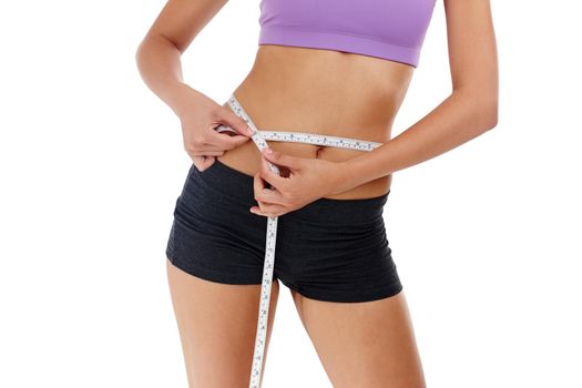 Whats your waistline target. an unrecognizable woman in gym clothes measuring her waist.