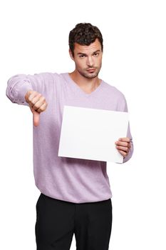 I dont approve...A handsome man holding a blank placard against a white background and showing a thumbs-down.