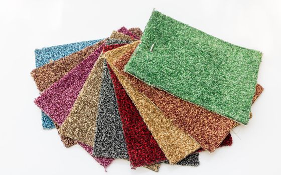 Different colors of carpet for display in a shop on isolated white background