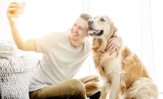 Young handsome man with his golden retriever dog