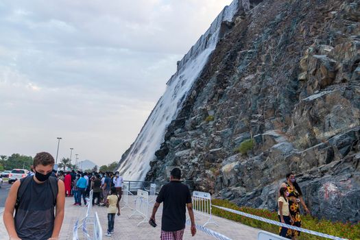 Sharjah, UAE - 07.20.2021 - Visitors at Sharjah amphitheatre waterfall, Khor Fakkan area. Sightseeing