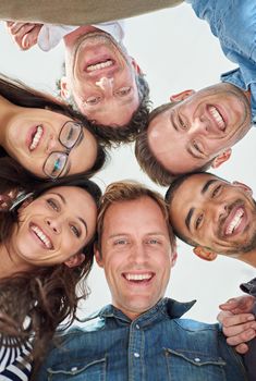 Winning with our positive attitude. Cropped low angle shot of six people putting their heads together in a circle.