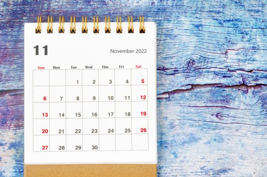 The November 2022 Monthly desk calendar for 2022 year on old blue wooden background.