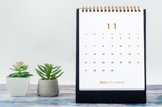 The November 2022 Monthly desk calendar for 2022 year on old blue wooden background