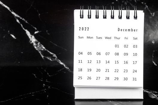 The December 2022 Monthly desk calendar for 2022 year on black marble background.