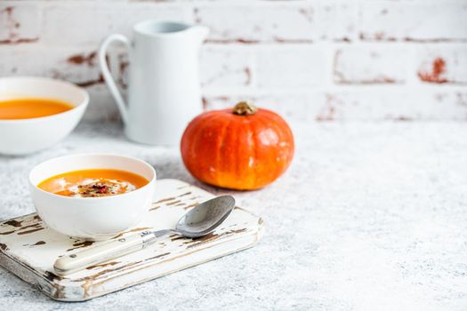 Pumpkin cream soup in white bowl copy space