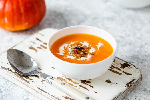 Pumpkin cream soup in white bowl