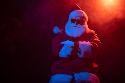 Portrait of Santa Claus in sunglasses in neon light.