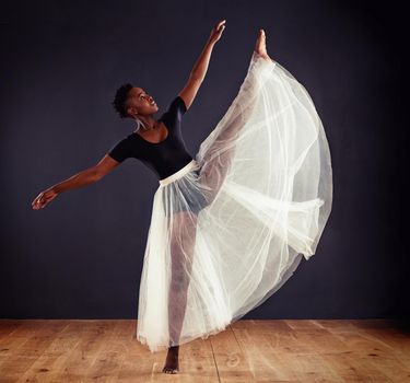Contemporary perfection. Young female contemporary dancer using a soft white white skirt for dramatic effect.