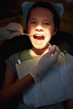 Under the dentists light. Closeup shot of a young girl having a checkup at the dentist.