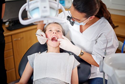 Taking a closer look. a female dentist and child in a dentist office