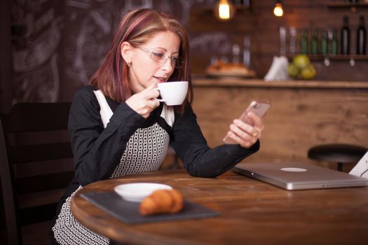 Adult businesswoman reading emails from her phone