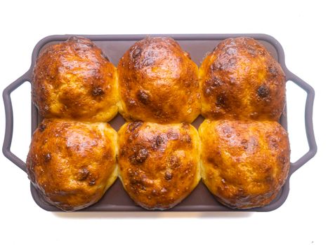 Lush buns with a golden crust in a silicone mold on top.