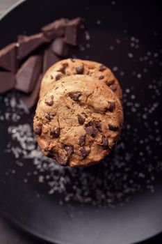 Chocolate chip cookies on black plate in studio photo