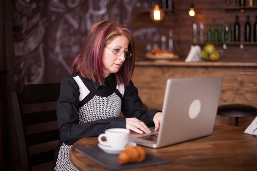 Adult business person wearing glasses works on laptop