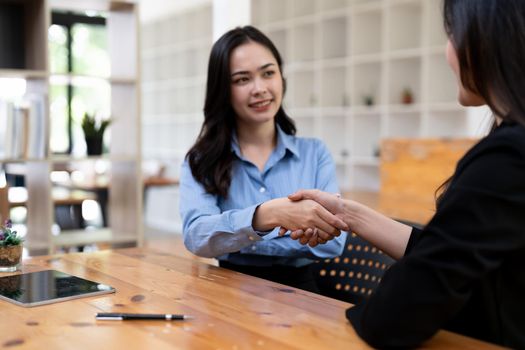 Portrait young asian woman interviewer and adviser shaking hands for a job interview. Business people handshake in modern office. Greeting deal concept