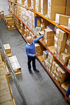 Tracking and tracing made simple. a mature man working inside in a distribution warehouse.