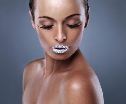 I eat diamonds for breakfast and shine all day. Studio shot of a beautiful young woman with sparkling lips.