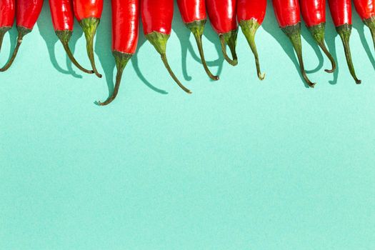 Red hot chilli peppers on minimal blue contrast background