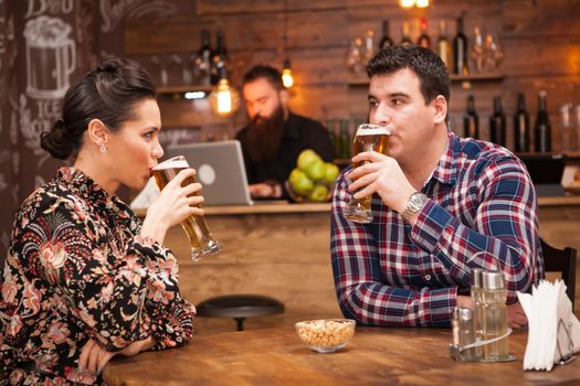 Romantic Couple drinking beer in in a hipster pub and making a toast.