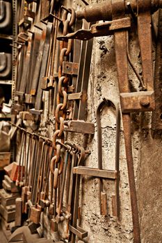 Vintage tools for the vintage craftsman. A range of well-used tools hanging on a textured wall.