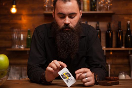 Bearded hipster bartender playing with his trick cards.