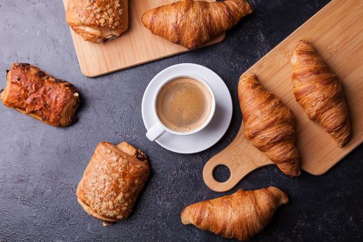 Assortment of pastries with coffee cup on wooden table background