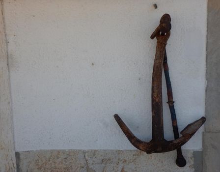 Old anchor on a white wall