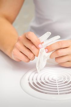 Beautician, doctor, or manicurist holds white latex protective gloves while preparing to wear them before providing services.