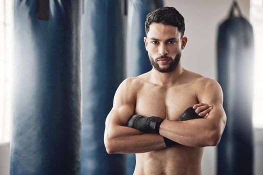 Fitness, boxer and gym of a man in sports professional for strength and motivation with arms crossed. Portrait of a male in strong and confident boxing at health club by punching bag after training