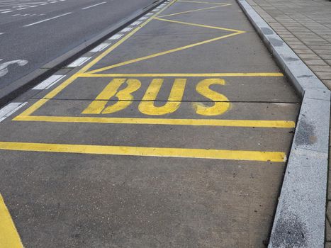 yellow bus stop lane sign on concrete