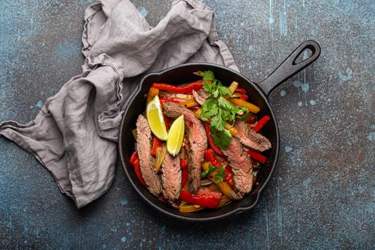 Mexican dish fajitas in cast iron pan from above