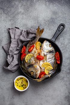 Grilled fish sea bream or dorado in cast iron skillet
