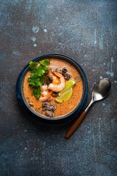 Thai soup Tom Yum with seafood in bowl from above