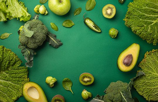 Creative layout food concept made of green fruit and vegetables on green background