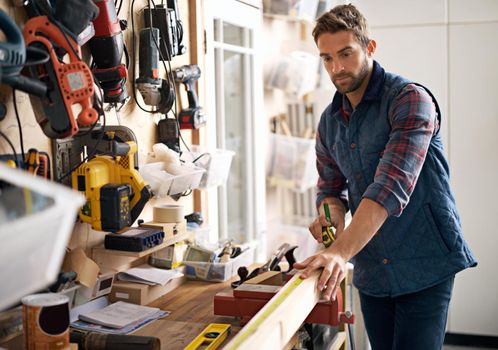 Visions of wooden success. Portrait of a handsome young handyman standing in front of his work tools.