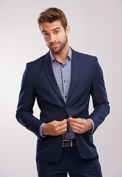 Hes a snappy dresser. Studio shot of a handsome well-dressed man against a gray background.