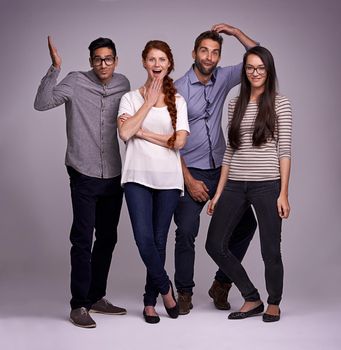 Lets put some humor into it. Studio shot of a group of diverse young people against a gray background.