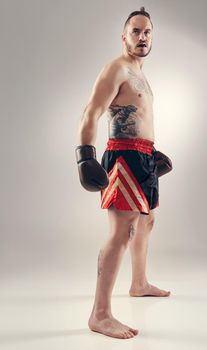 You wanna mess with me. a serious MMA fighter standing isolated on white.